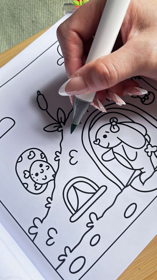 Person colouring a bold and easy forest animal design with a black fine-tip marker pen.