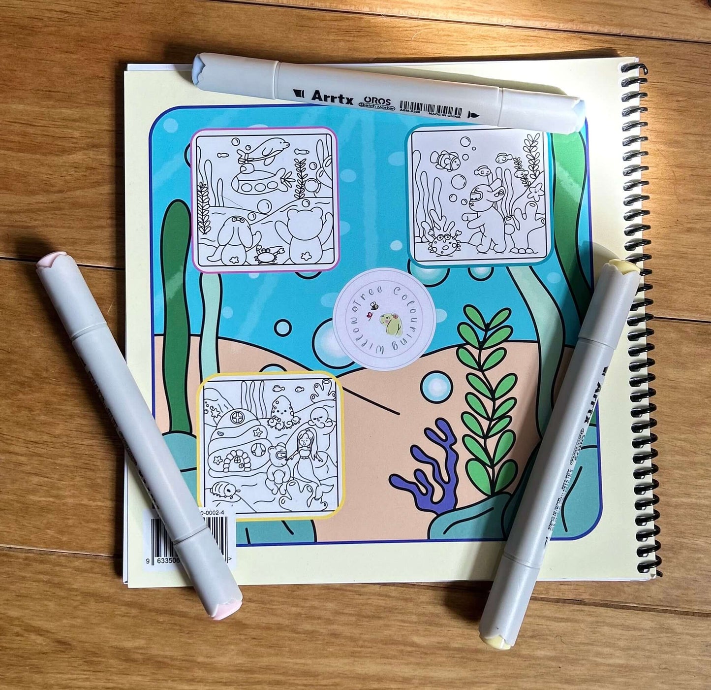 Finished blue ocean scene inside the lay-flat spiral bound cute sea animal colouring book.